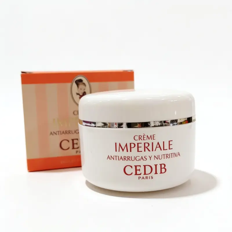 Un frasco blanco con la etiqueta «Crema Cedib Imperial Antiarrugas día y noche 100 ml» se encuentra delante de su caja naranja y rosa, en la que aparece una pequeña ilustración del rostro de una mujer.