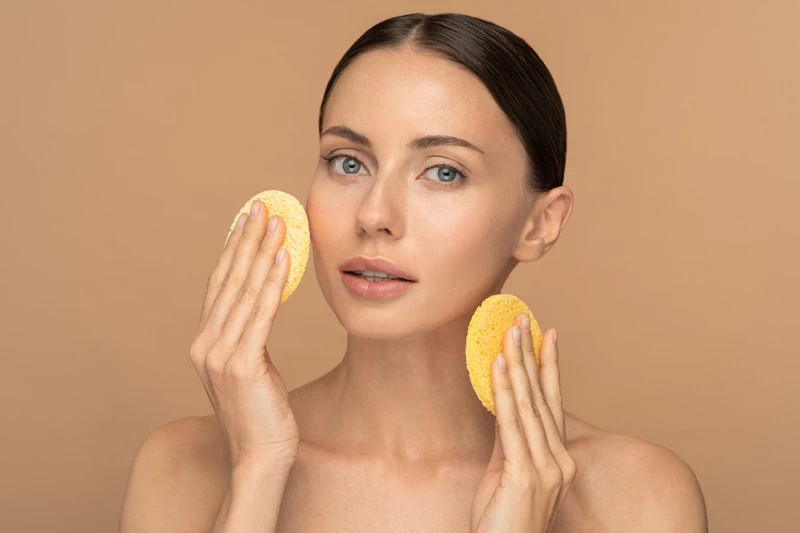 Mujer con dos esponjas de maquillaje