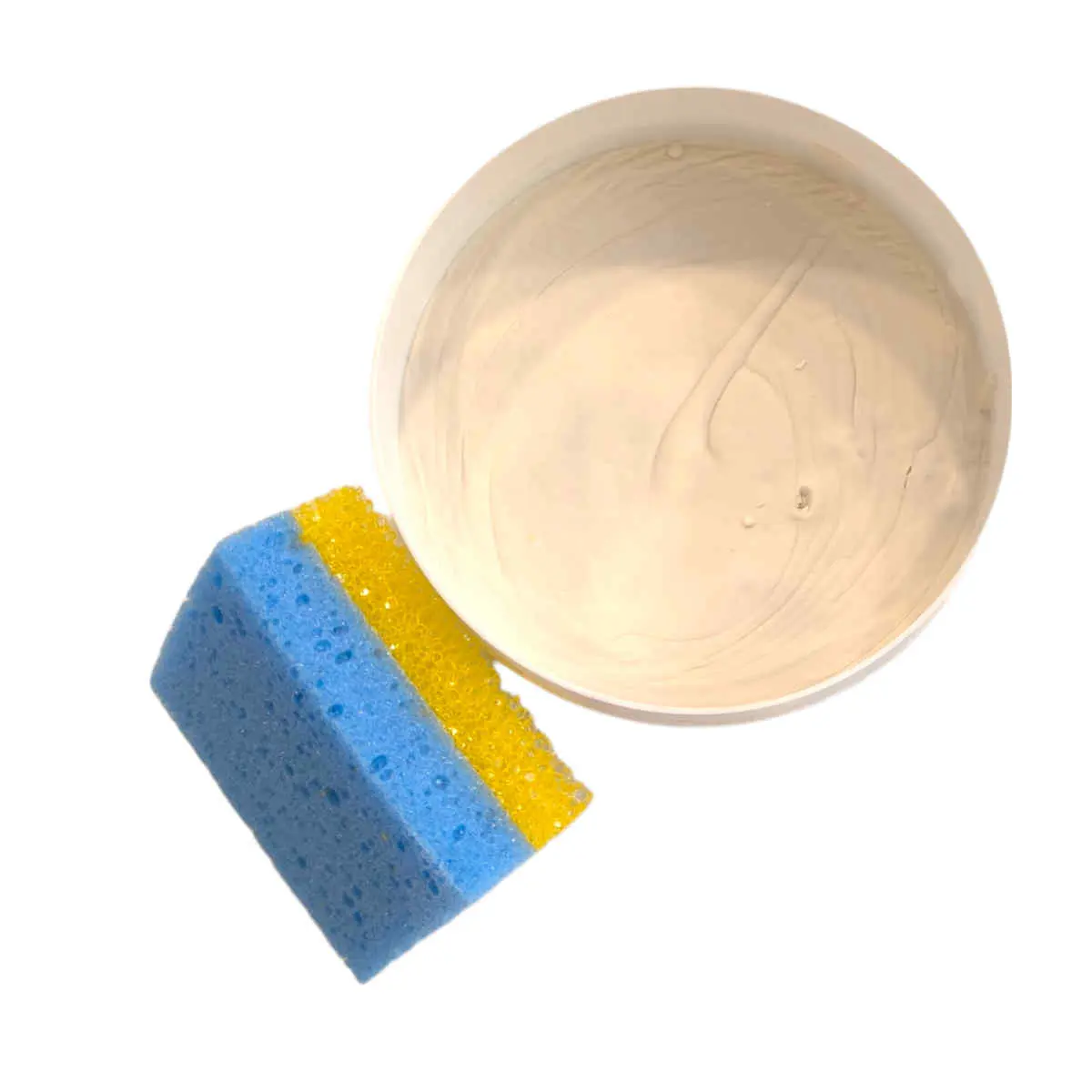 La Piedra blanca de limpieza Starwax 375gr, un envase redondo de pasta limpiadora blanca, se muestra junto a una esponja de cocina azul y amarilla sobre fondo blanco.