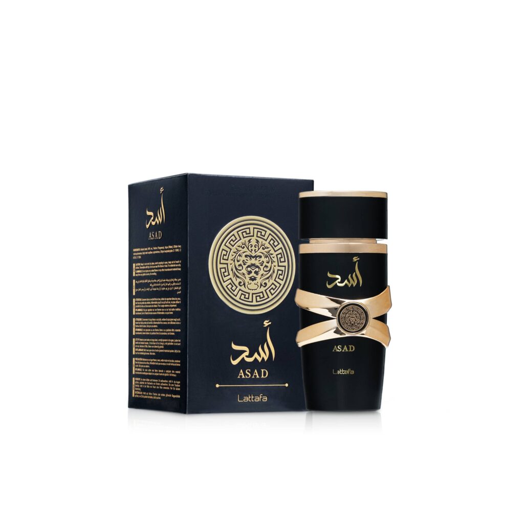 asad-02 Un frasco de perfume Lattafa Asad EDP de 100 ml, negro y dorado, junto a su estuche a juego, ambos adornados con escritura árabe y una ornamentada cabeza de león dorada.