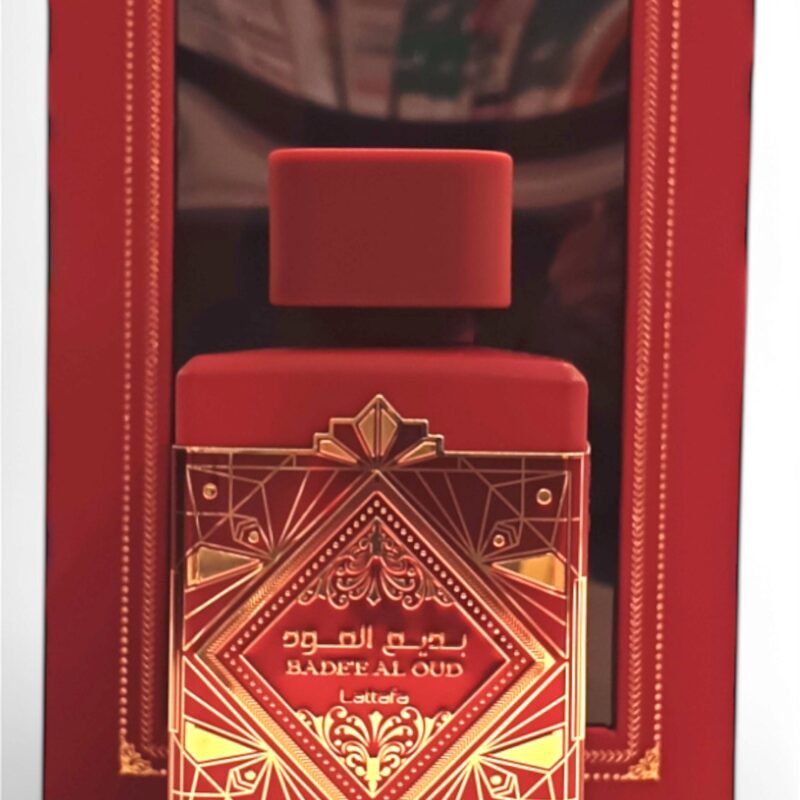 badee al oud sublime front center El frasco negro y dorado de Lattafa Asad Zanzibar EDP 100 ml se encuentra delante de su caja a juego, ambas adornadas con intrincados motivos geométricos y escritura árabe.