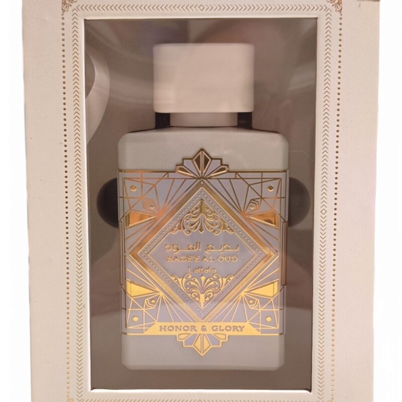 honor and glory boxed Un frasco de perfume en caja etiquetado Lattafa Asad Zanzibar EDP 100ml, con diseños geométricos dorados sobre fondo blanco y visibles a través de una ventana en el envase.