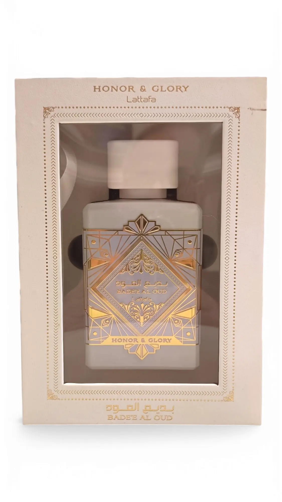 Un frasco de perfume en caja etiquetado Lattafa Asad Zanzibar EDP 100ml, con diseños geométricos dorados sobre fondo blanco y visibles a través de una ventana en el envase.