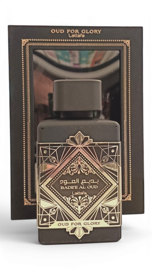 El frasco negro de Lattafa Asad Zanzibar EDP 100 ml se encuentra delante de su caja negra y dorada decorada con motivos geométricos y árabes.