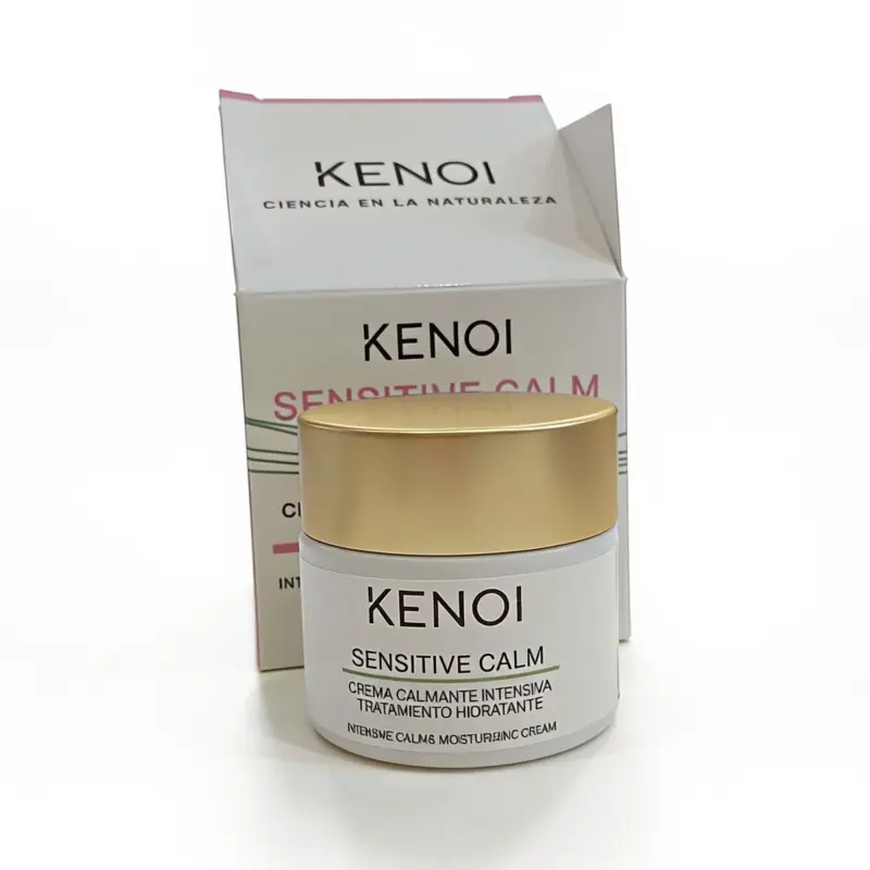 Se muestra un frasco de crema calmante Kenoi Sensitive Calm 24H de 50 ml frente a su caja a juego, ambos con detalles en blanco y dorado.