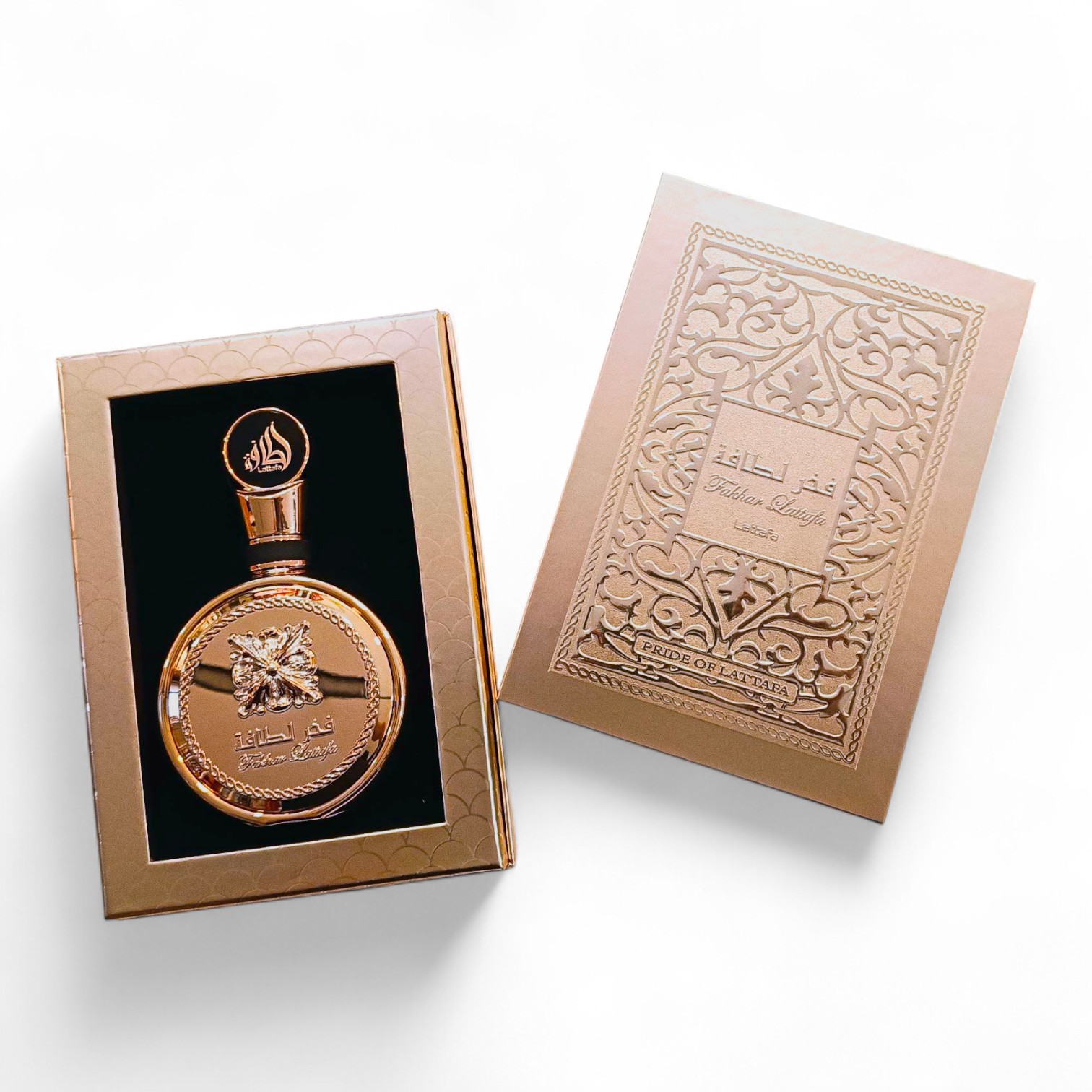 El perfume Lattafa Fakhar Gold Extrait EDP de 100 ml se presenta en un frasco dorado con escritura árabe junto a una tapa ornamentada a juego, ambos con intrincados motivos y texto, todo ello sobre un fondo blanco.