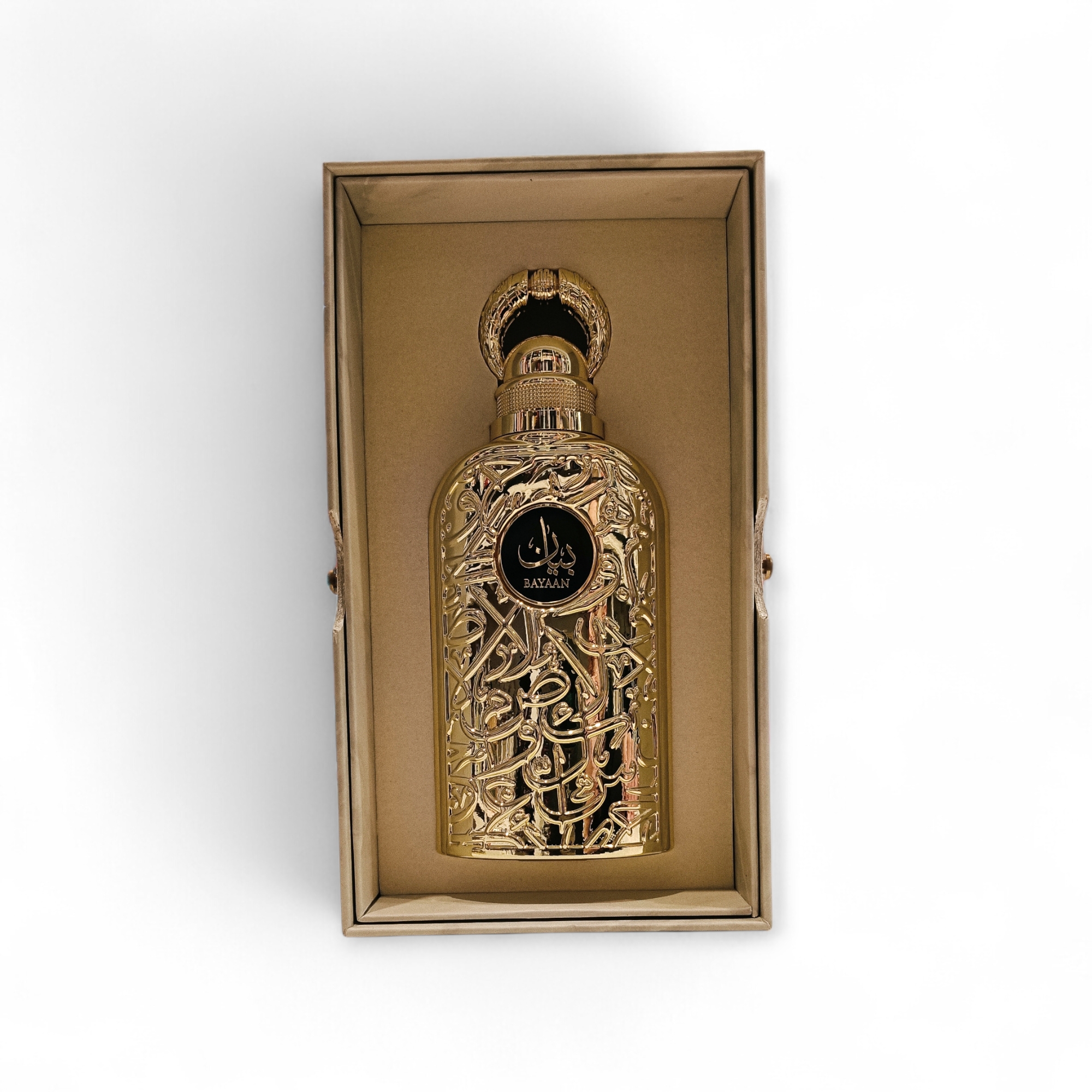 Lattafa Bayaan unisex EDP 100ml: Un frasco de perfume ornamentado en oro con una intrincada caligrafía árabe, en posición vertical en una caja rectangular dorada con un suave interior, que se muestra sobre un fondo blanco.