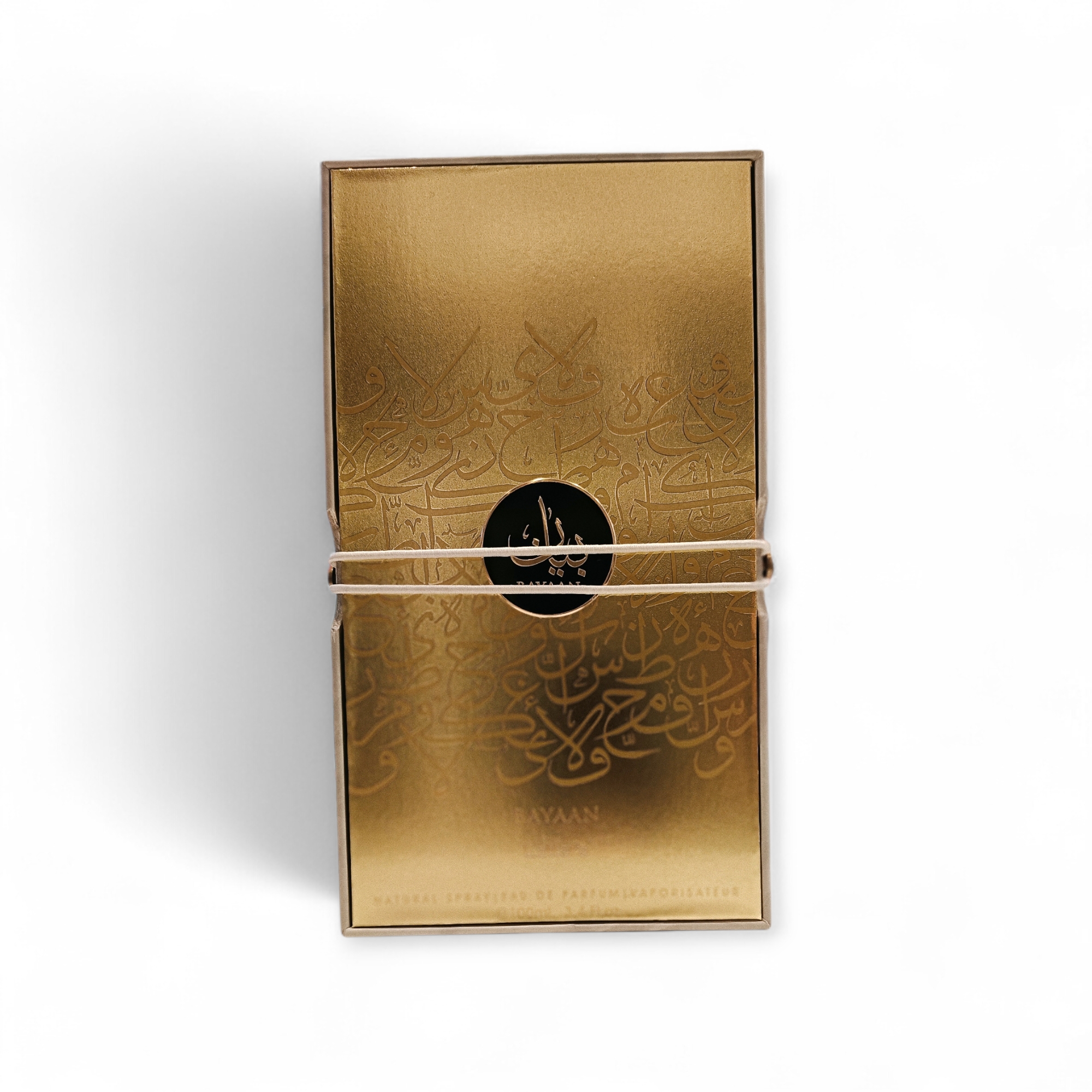 El Lattafa Bayaan EDP unisex de 100 ml se presenta en un estuche rectangular dorado con caligrafía árabe en relieve, un emblema circular negro en el centro y se sujeta con una fina banda elástica sobre fondo blanco.