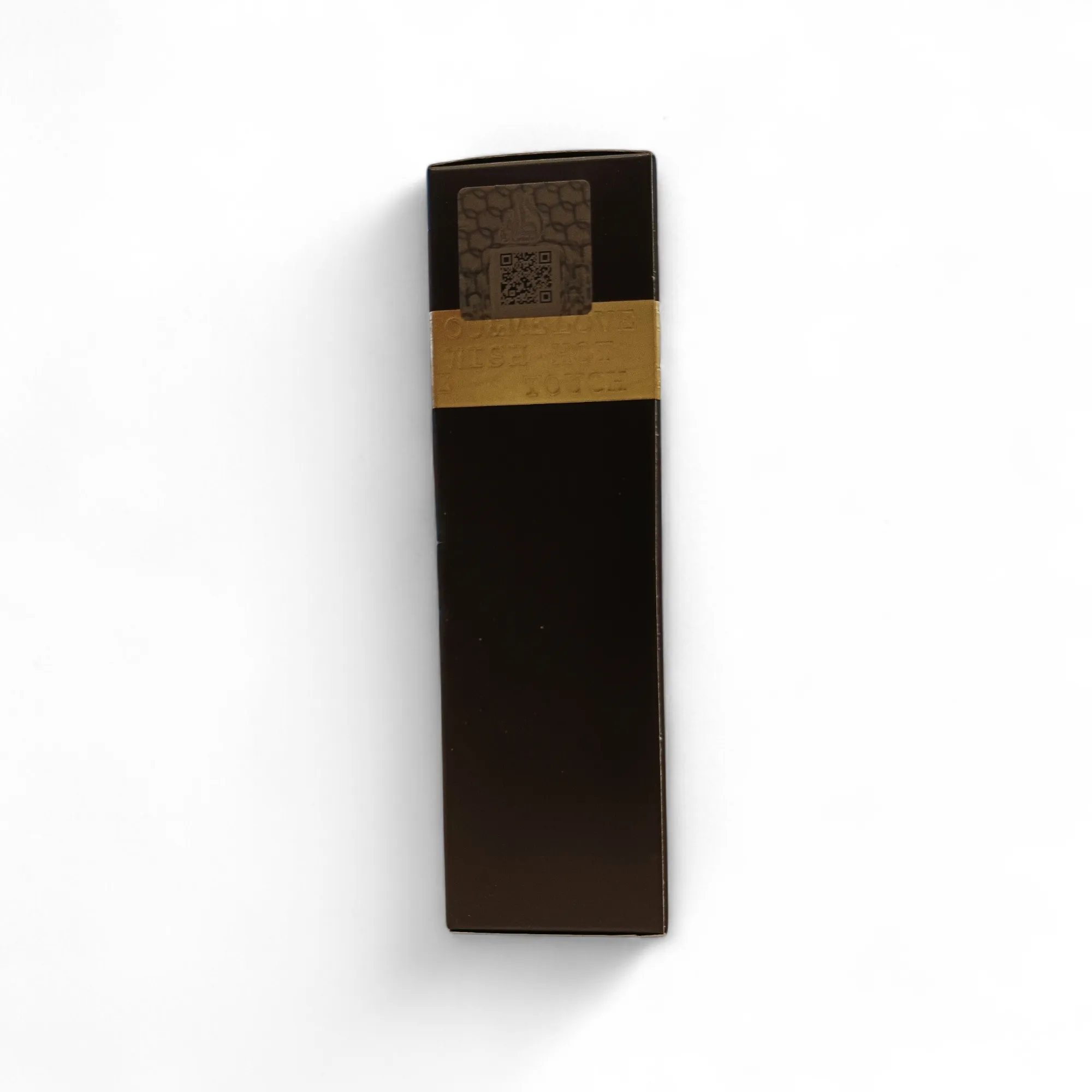 Caja rectangular de cosméticos de color marrón oscuro con una banda dorada cerca de la parte superior y una pegatina con un código QR en la parte superior, fotografiada sobre fondo blanco.