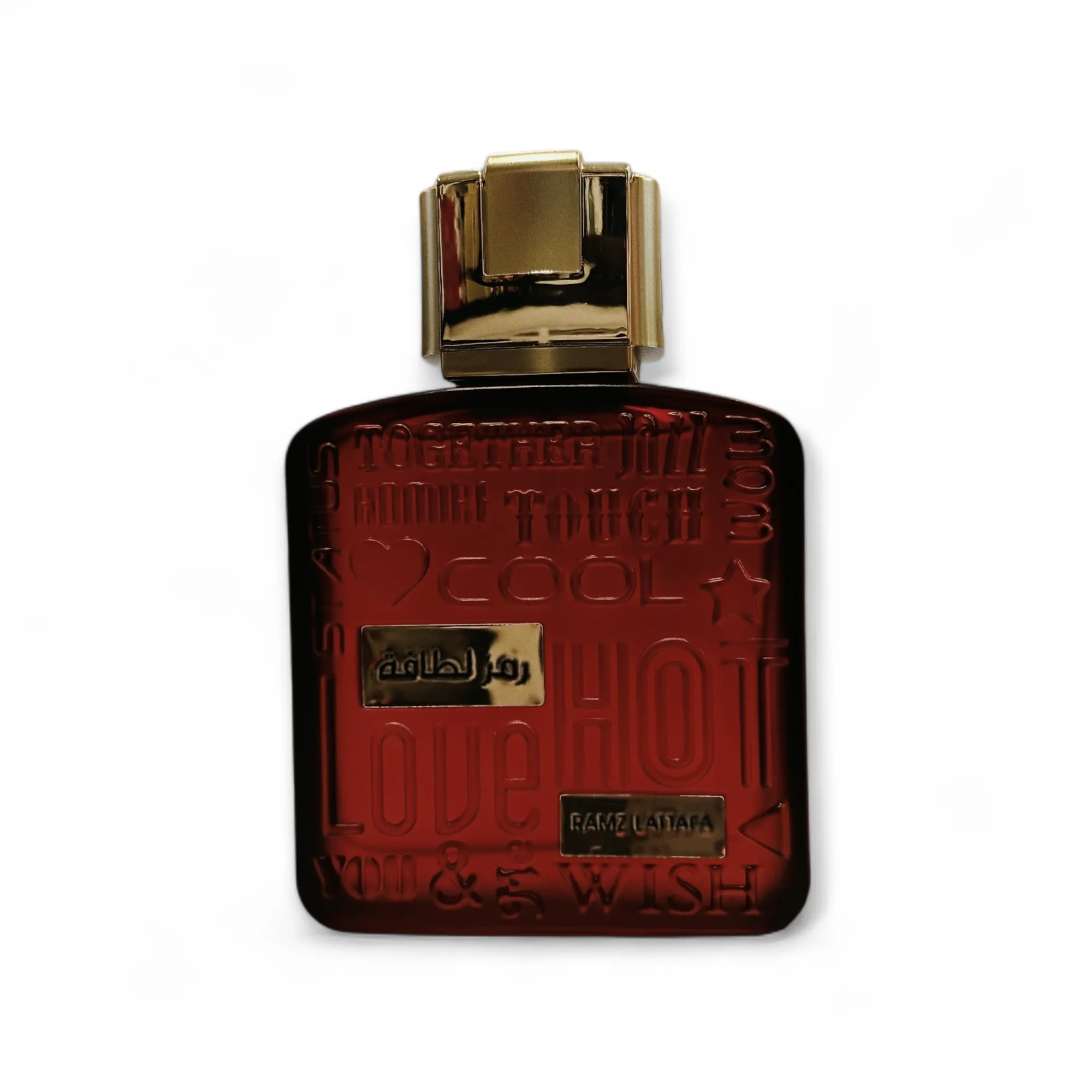 Frasco de perfume de color ámbar oscuro con tapón dorado. La parte frontal del frasco lleva grabadas palabras como Love, HOT, COOL y TOUCH, junto con algunos textos en árabe y símbolos decorativos.