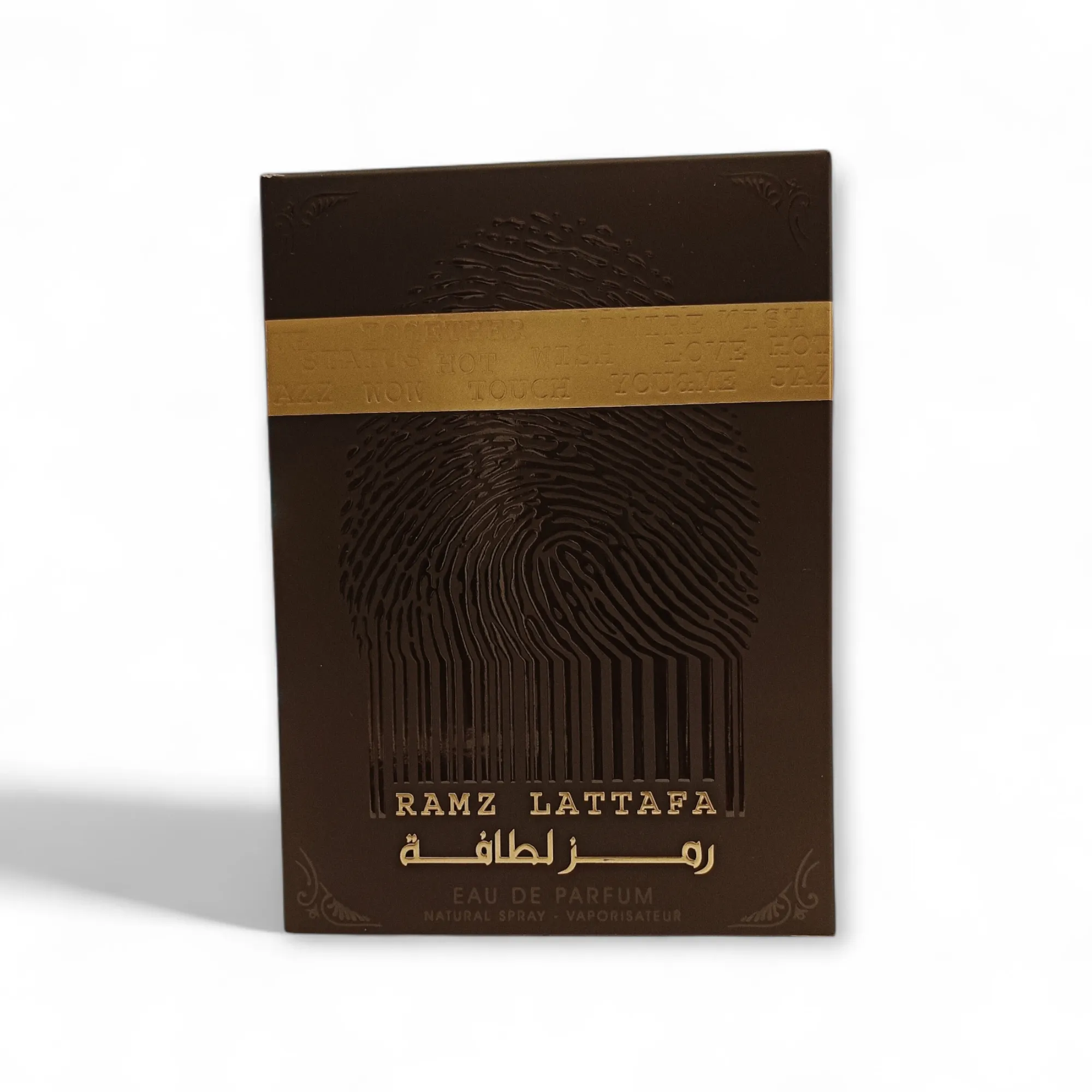 Caja para perfumes de color marrón oscuro con texto dorado, que incluye RAMZ LATTAFA y escritura árabe. El diseño presenta una gran huella dactilar y una banda dorada en la parte superior con la inscripción DONT TOUCH repetida.