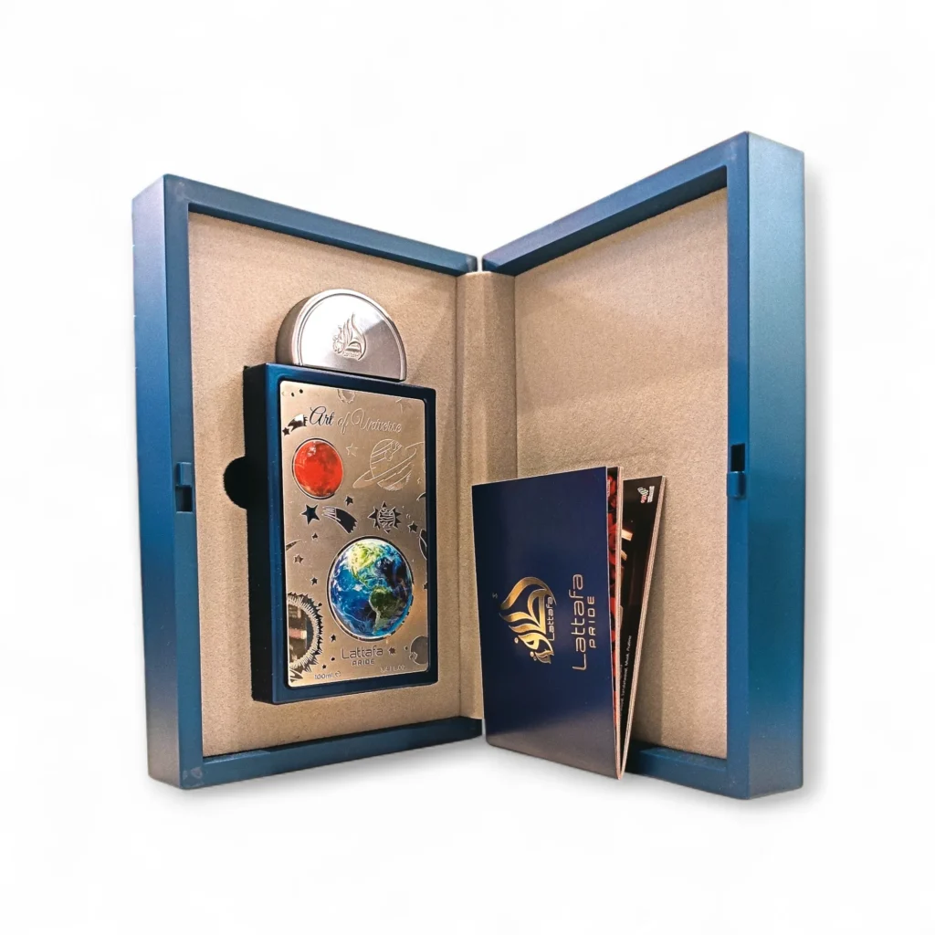 Una caja azul que se despliega abierta, revelando una tarjeta metálica coleccionable con diseños de temática espacial inspirados en Art of Universe Lattafa Pride, una moneda redonda de plata y un cuadernillo con la palabra Libra y un logotipo impresos en la portada. Una caja azul que se despliega abierta, revelando una tarjeta metálica coleccionable con diseños de temática espacial inspirados en Art of Universe Lattafa Pride, una moneda redonda de plata y un cuadernillo con la palabra Libra y un logotipo impresos en la portada.
