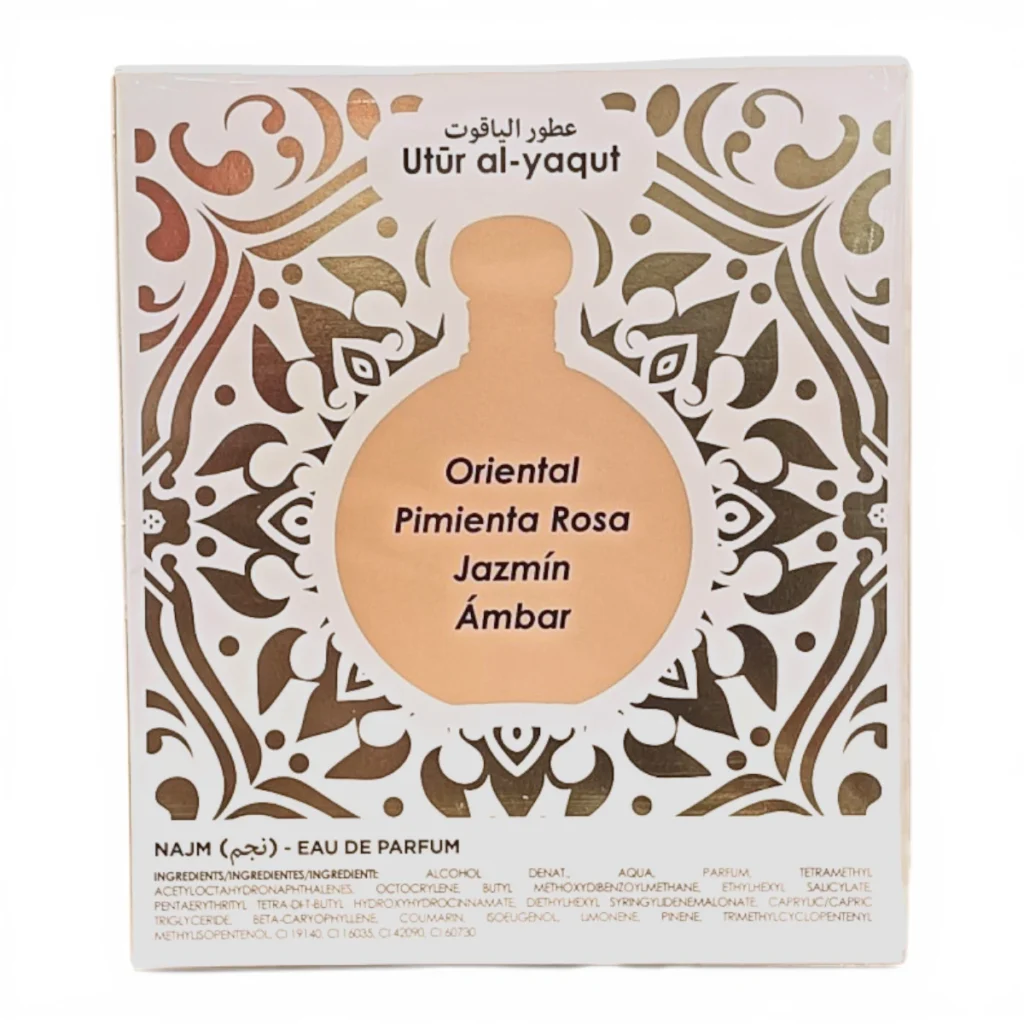 Una caja de perfume etiquetada como Utúr al-yaqut presenta un motivo decorativo dorado con una ventana circular que muestra las notas olfativas: Oriental, Pimienta Rosa, Jazmín, Ámbar, y una lista de ingredientes en la parte inferior. Una caja de perfume etiquetada como Utúr al-yaqut presenta un motivo decorativo dorado con una ventana circular que muestra las notas olfativas: Oriental, Pimienta Rosa, Jazmín, Ámbar, y una lista de ingredientes en la parte inferior.