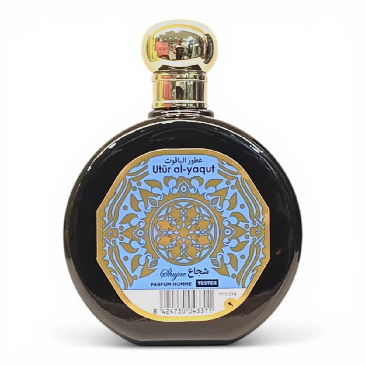 Frasco redondo de perfume negro con tapón dorado. La etiqueta presenta motivos geométricos azules y dorados y reza Utūr al-yaqūt en árabe e inglés, junto con Shiyaac PARFUM HOMME TESTER.