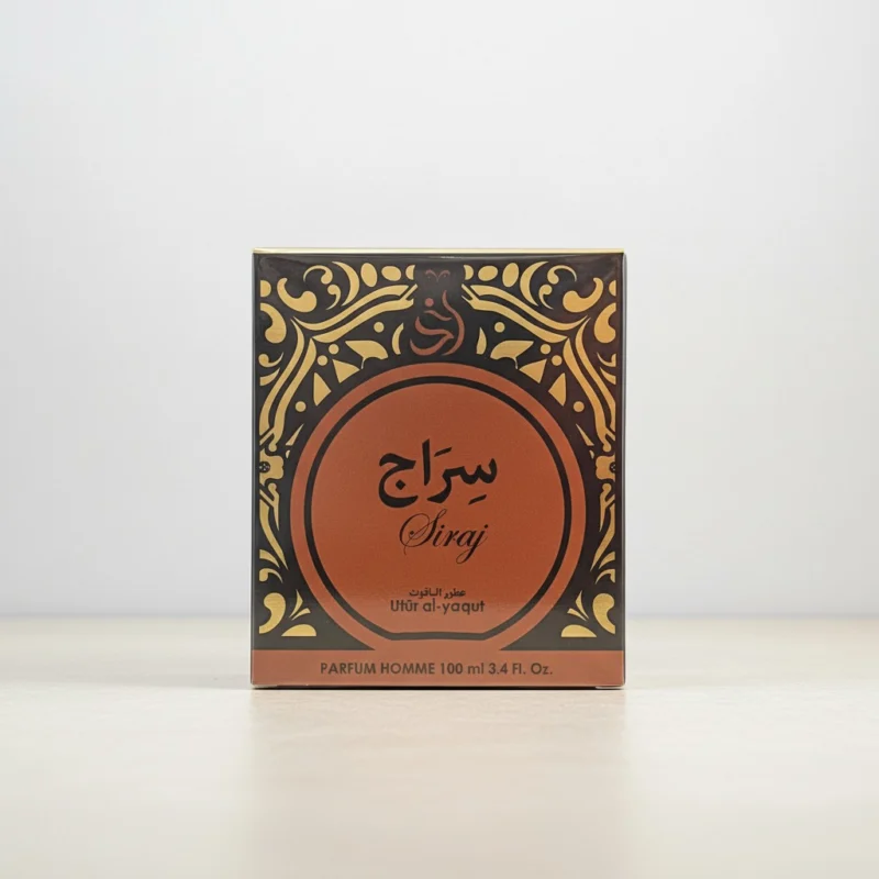 Perfumero cuadrado con motivos ornamentales dorados y marrones, texto en árabe e inglés que reza Siraj y Uttar al-yaqut. La caja tiene un fondo claro y liso.