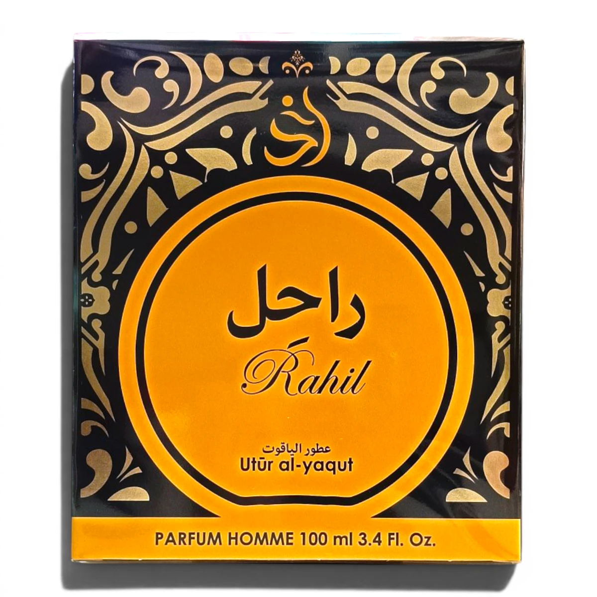 Caja de perfume cuadrada con diseños ornamentales en negro y dorado. En el centro aparece Rahil en árabe e inglés, junto con Utūr al-yaqūt y Parfum Homme 100 ml 3.4 Fl. Oz. en amarillo y negro.