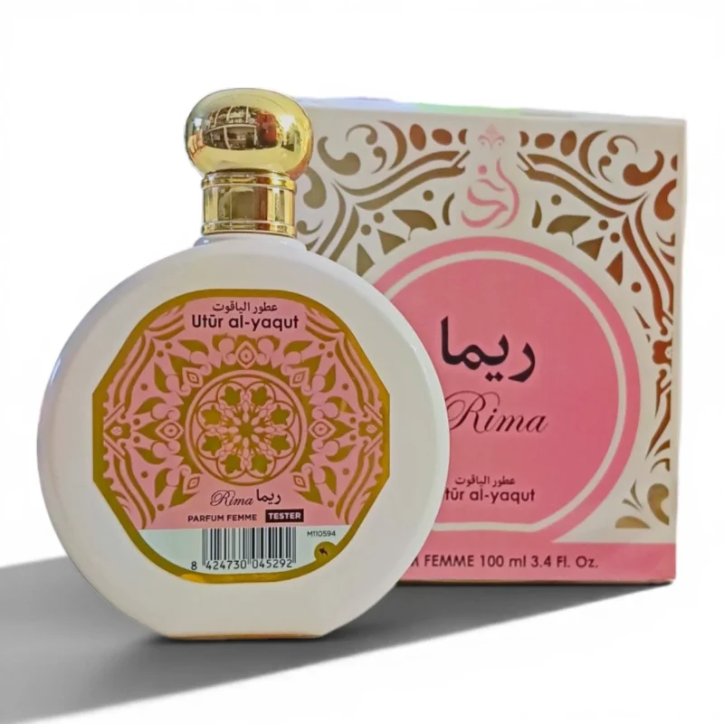 Un frasco redondo de perfume blanco con tapón dorado y la etiqueta Rima Utr al-yaqut delante de una caja decorativa a juego. Ambas presentan motivos florales rosas y dorados y texto en árabe. El frasco está marcado como probador.