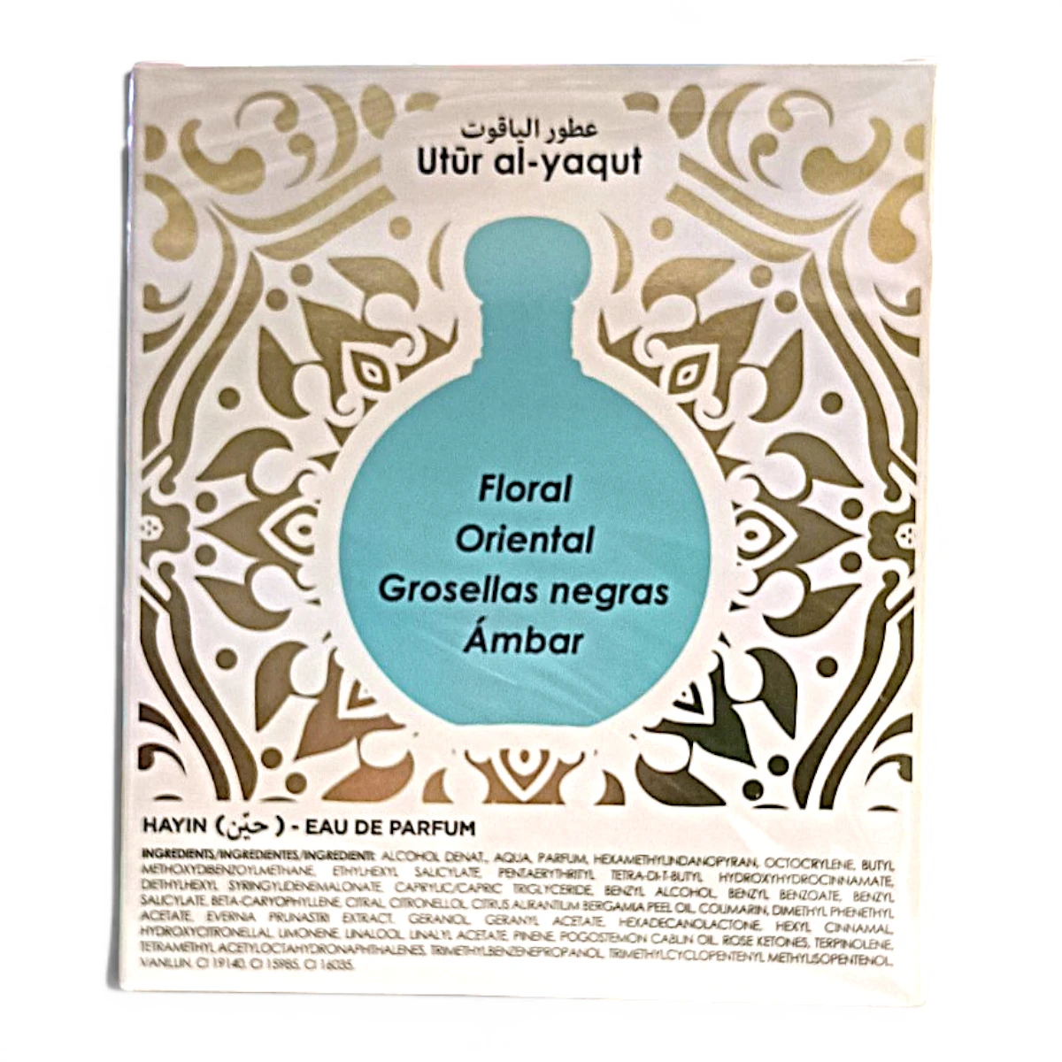 Un sobre de perfume con la etiqueta Utûr al-yaqut presenta la silueta de un frasco azul con las notas olfativas Floral, Oriental, Grosellas negras, Ámbar sobre un fondo decorativo blanco y dorado. Los ingredientes se enumeran a continuación.