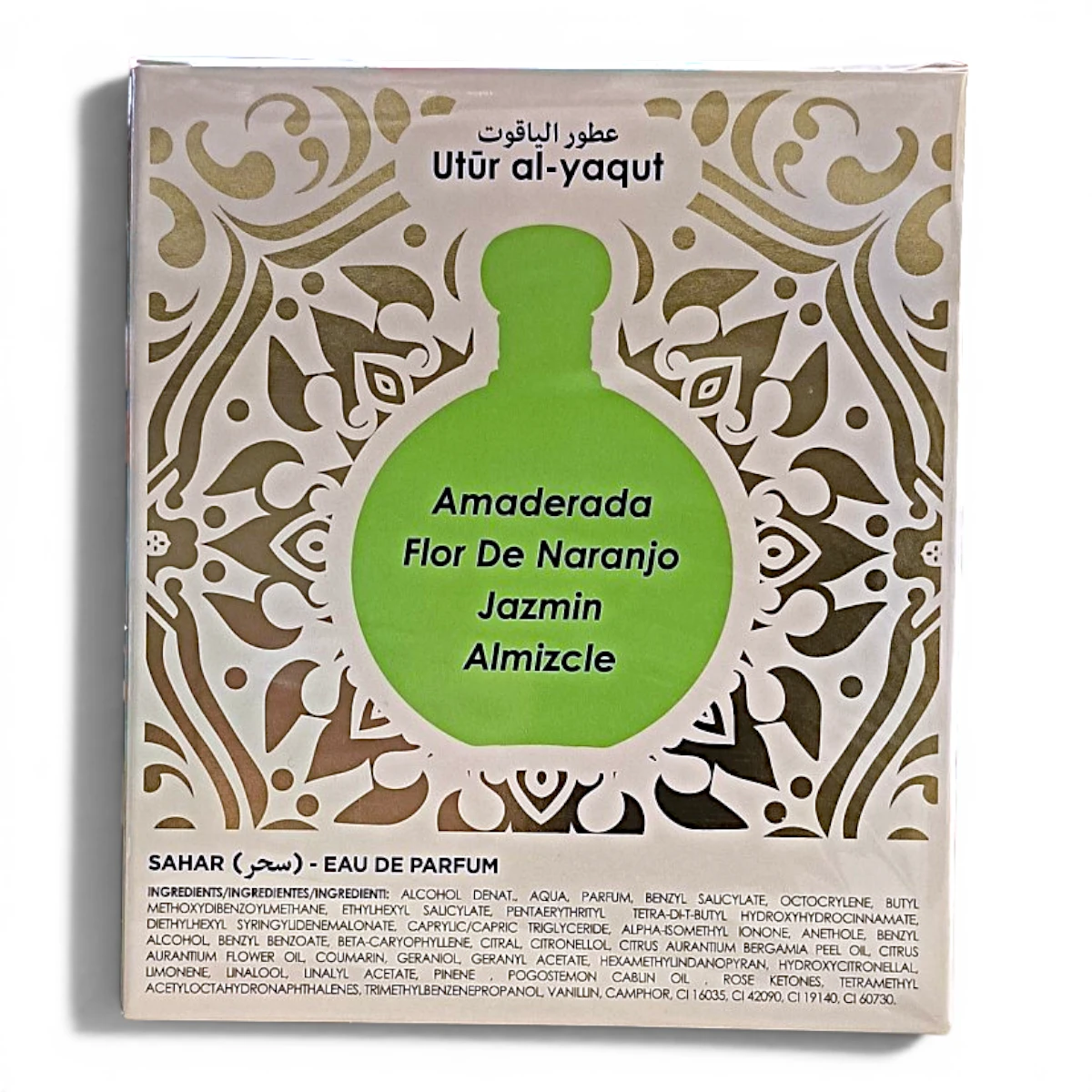 Una caja de perfume etiquetada como Utūr al-yaquṭ presenta un gráfico de una botella verde con las notas olfativas: Amaderada, Flor de Naranjo, Jazmín y Almizcle. La imagen del frasco está rodeada de motivos decorativos dorados.