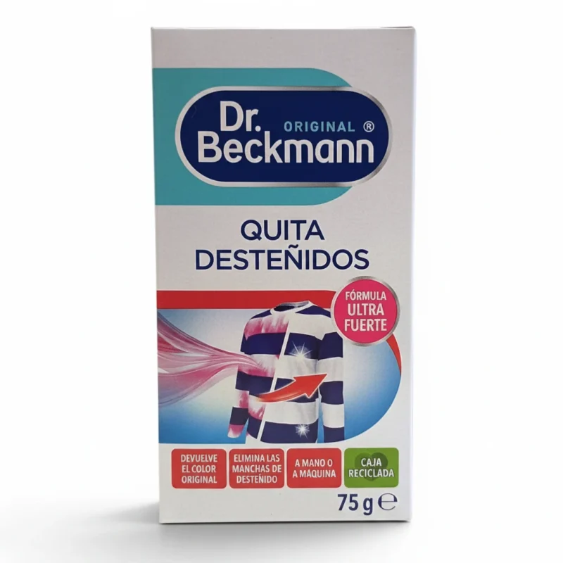 Parte frontal de una caja de «Dr. Beckmann Original Quitadesteñidos», en la que se muestra una camiseta a rayas de la que se están eliminando manchas causadas por la transferencia de color. El texto destaca características como la restauración del color y la eliminación de manchas. El contenido de la caja es de 75 g.