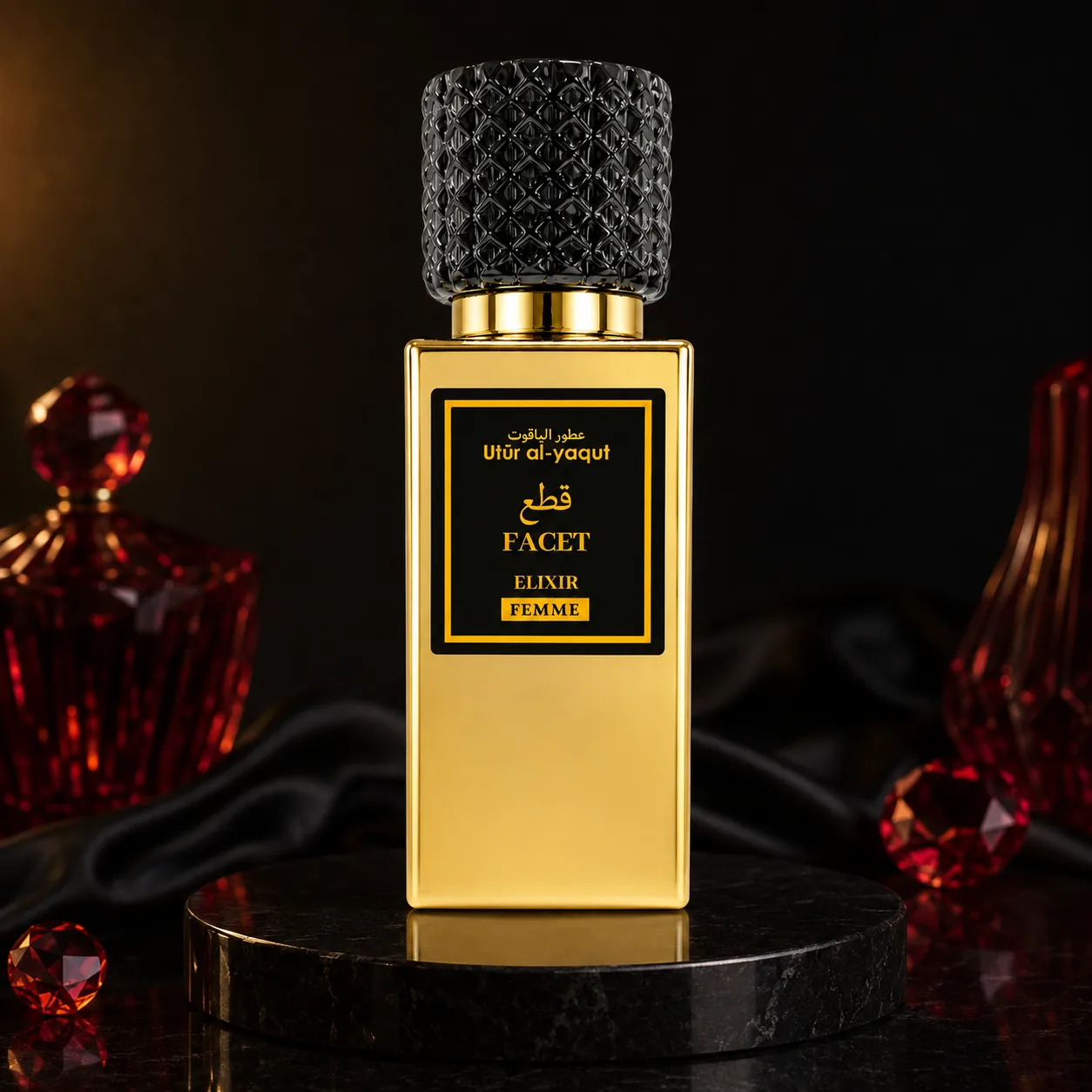 Un frasco de perfume dorado con un tapón negro texturizado en el que se lee «Utur al-Yaqut Elixir Facet Perfume Mujer 50 ml» descansa sobre una superficie de mármol negro, con adornos de cristal rojo y tela negra al fondo.