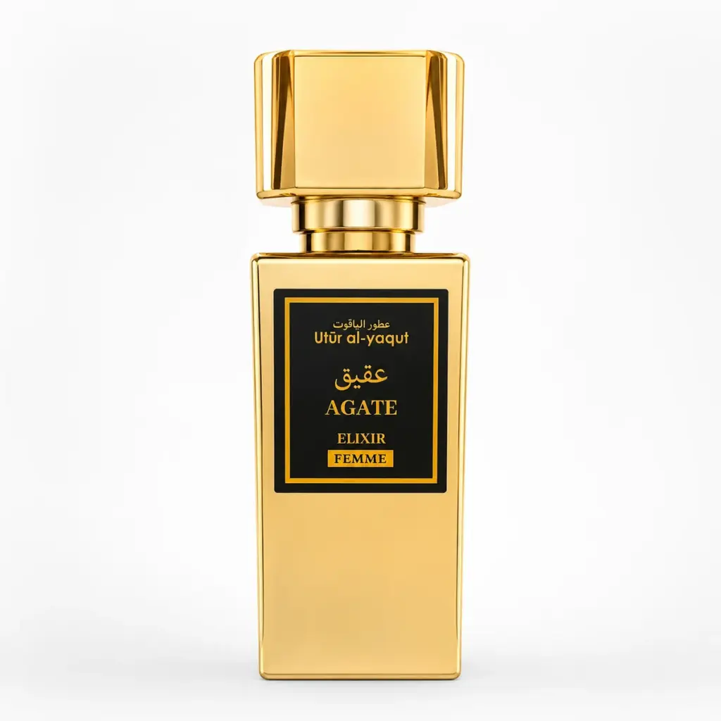 Un frasco de perfume rectangular dorado con la etiqueta «Agate Elixir Femme», con detalles en negro y dorado y texto en árabe, sobre un fondo blanco liso.