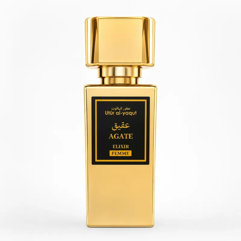 Un frasco de perfume rectangular dorado con la etiqueta «Agate Elixir Femme», con detalles en negro y dorado y texto en árabe, sobre un fondo blanco liso.