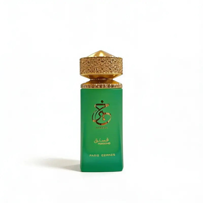 Un frasco de perfume verde con inscripciones en árabe doradas y un tapón dorado ornamentado, colocado en posición vertical sobre un fondo blanco liso. En la parte inferior del frasco se lee «Paris Corner».
