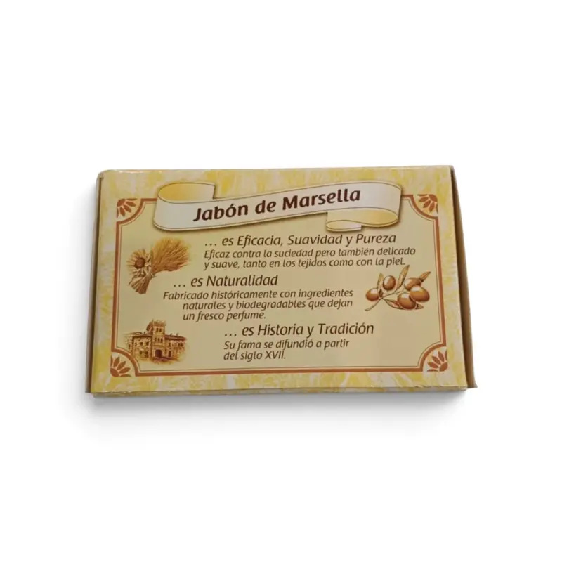 Una caja rectangular de jabón de Marsella Omino Bianco en pastilla de 250 g, con texto en español que destaca su eficacia, sus ingredientes naturales y su tradición. La caja amarilla muestra imágenes de trigo, aceitunas y un edificio.
